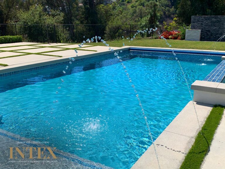 Outdoor swimming pool with water fountains.