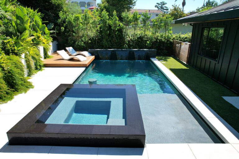 Modern backyard pool with square spa and loungers
