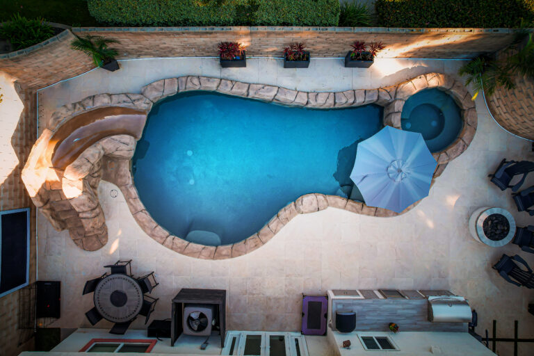 Backyard pool with slide and seating area.