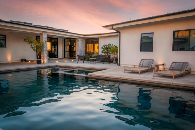 Modern house with pool at sunset.