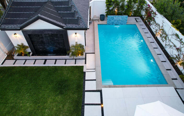 Modern backyard with pool and small building.