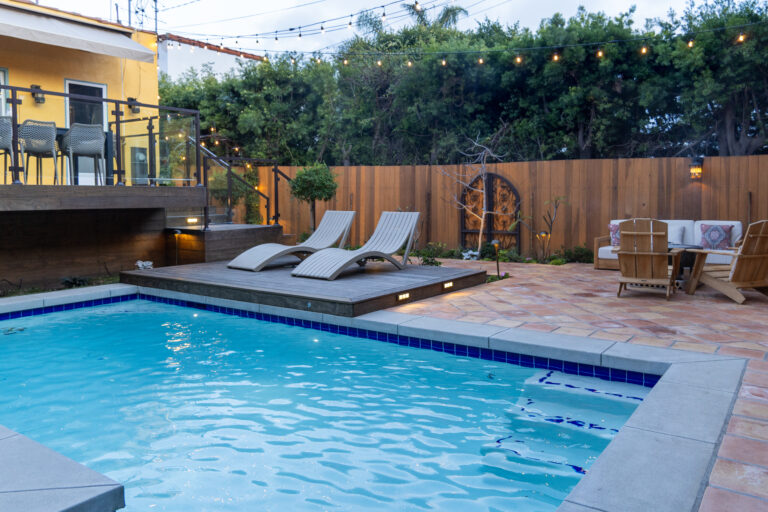 Backyard pool with lounge chairs and patio.